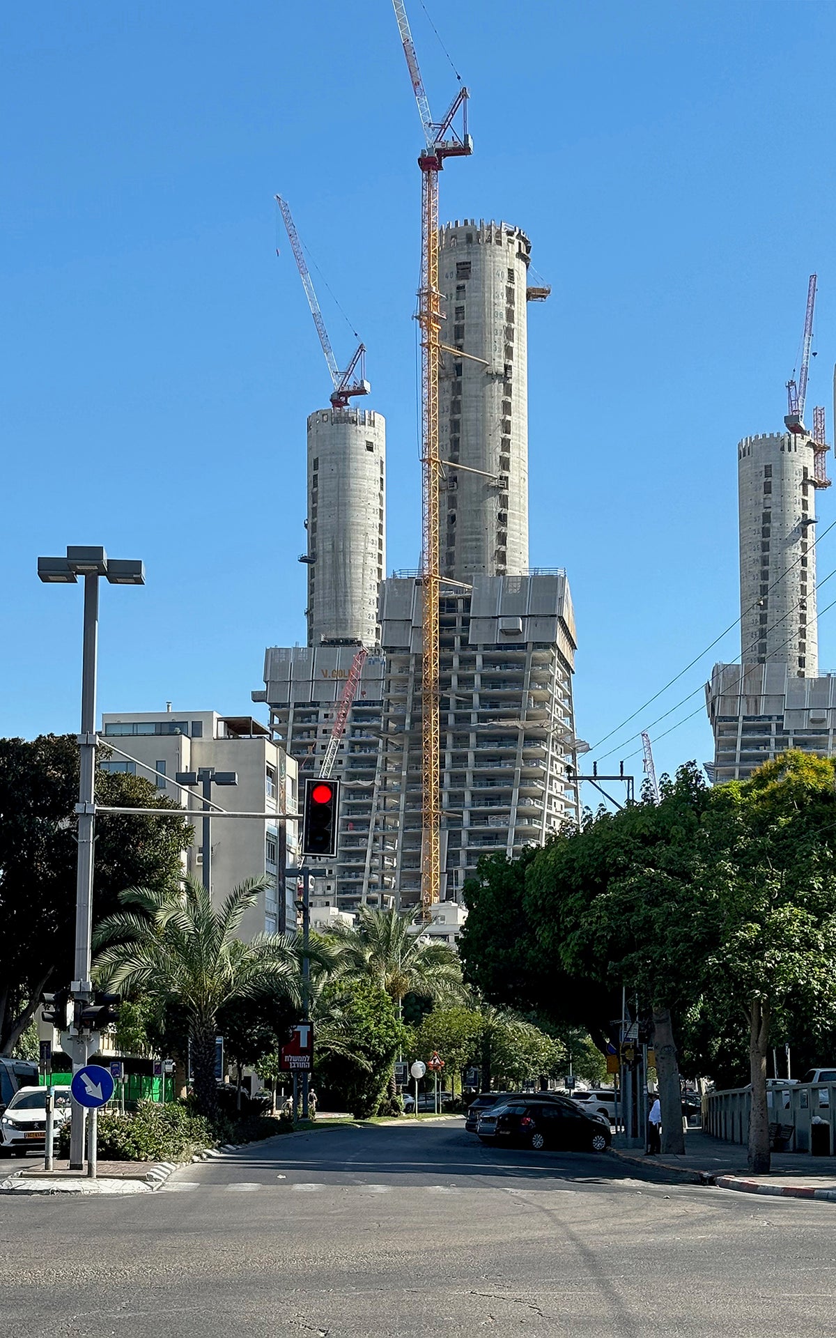 Photography art print featuring tall buildings being built with cranes against a clear blue sky.